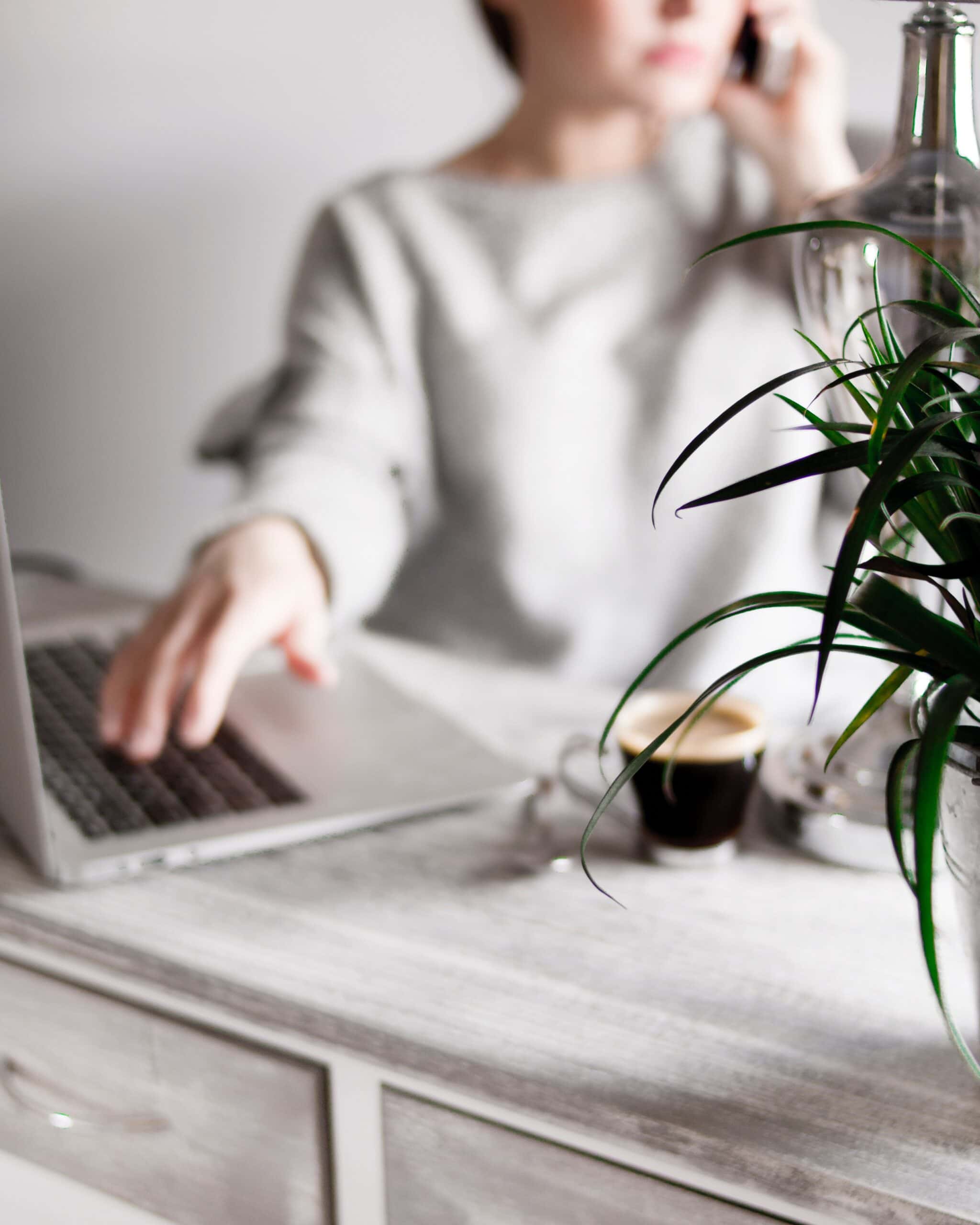 woman on phone with laptop